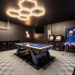 A room with a foosball table, a bar area, and two arcade machines. - Disney Luxury Villa | Epic Arcade | LED Night Pool (Davenport)