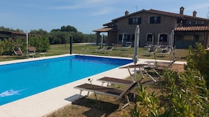 A rectangular swimming pool with a clear blue water surface, surrounded by a tiled deck. - Villa Klinai (Cerveteri)