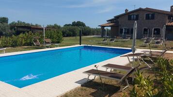 A rectangular swimming pool with a clear blue water surface, surrounded by a tiled deck.