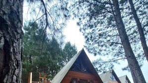 A cabin with a wooden deck and a staircase leading to the entrance. - Estalagem Refúgio Do Capão (Cambara do Sul)