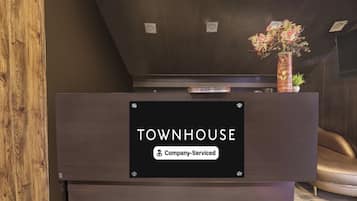 A reception desk with a sign that reads 'TOWNHOUSE' and a label indicating 'Company-Serviced.'