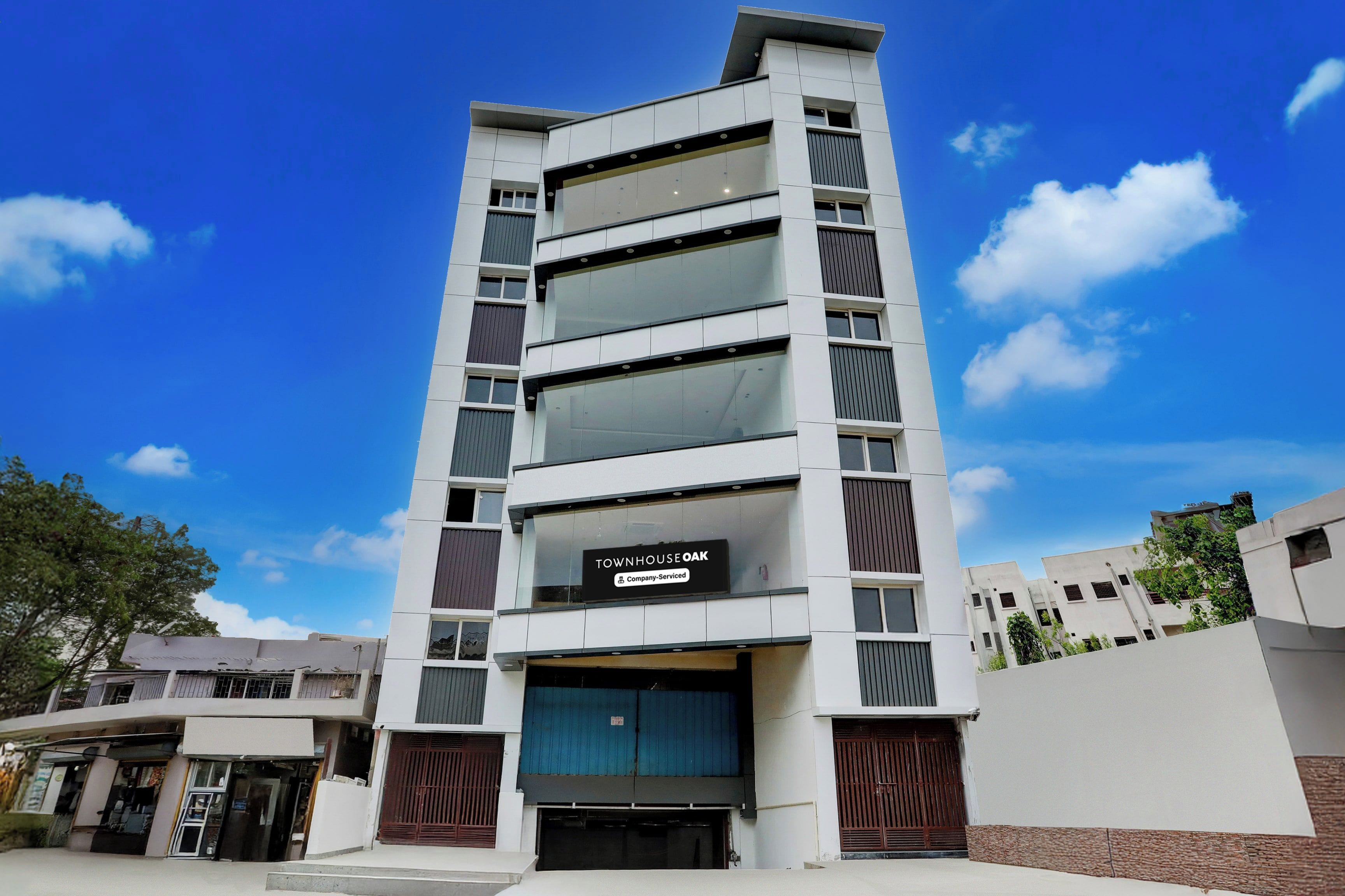 A multi-story building with a sign reading 'TOWNHOUSE OAK' indicating a residential complex.