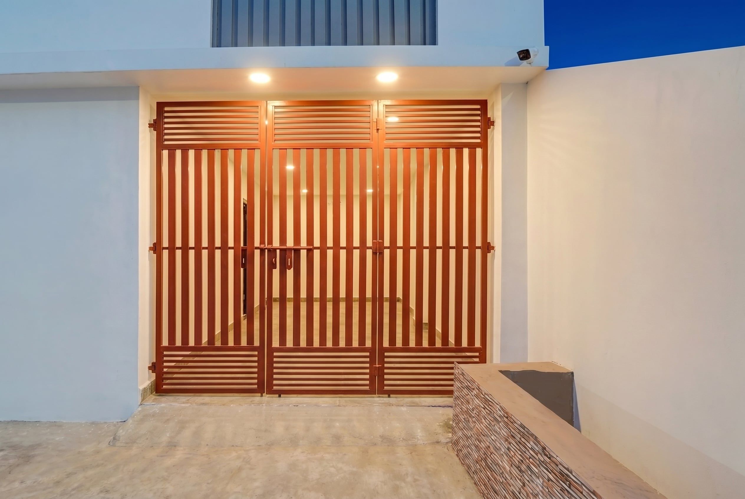 A modern entrance with a wooden gate and a small step leading up to a door.