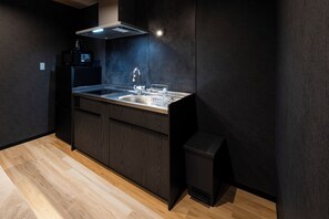 Una cucina moderna con forno a microonde integrato, lavello in acciaio inox e mobili in legno.