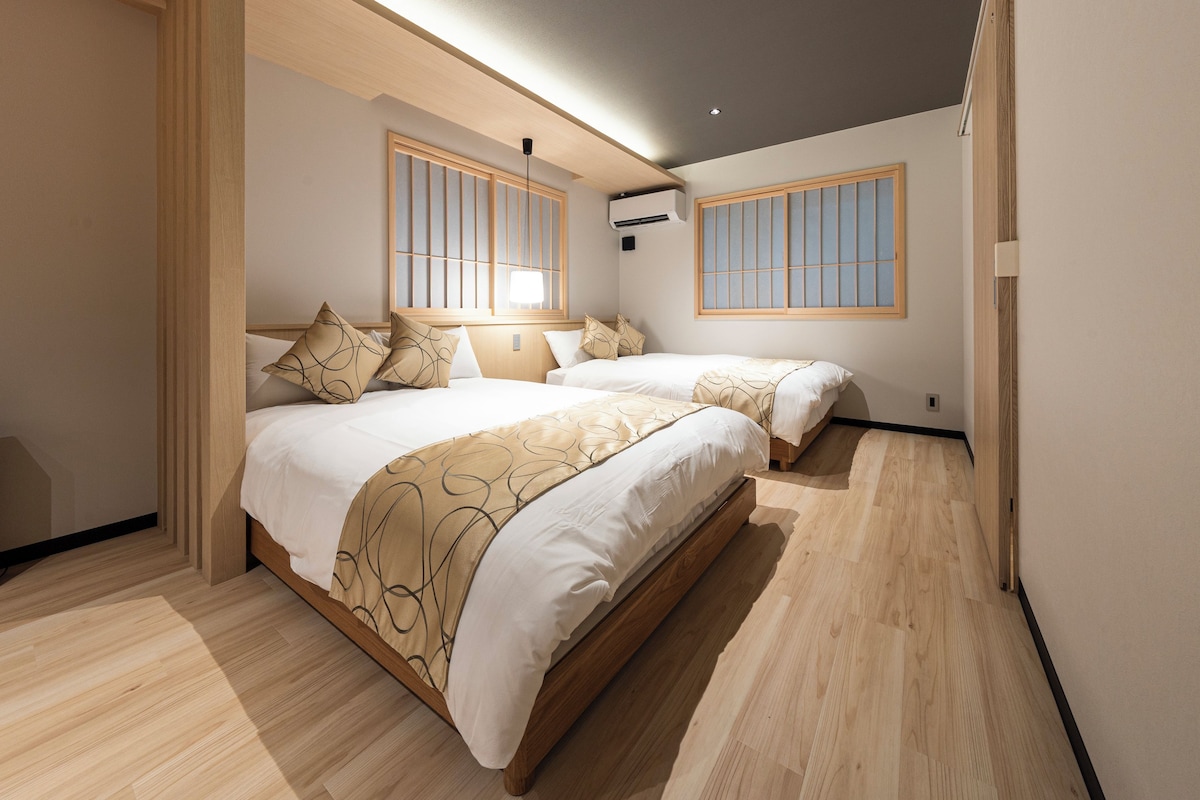 Een moderne hotelkamer met een groot bed, twee nachtkastjes, een raam met uitzicht en een airconditioning.