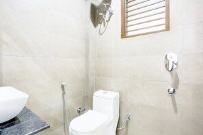 Un baño con inodoro, ducha y lavamanos.