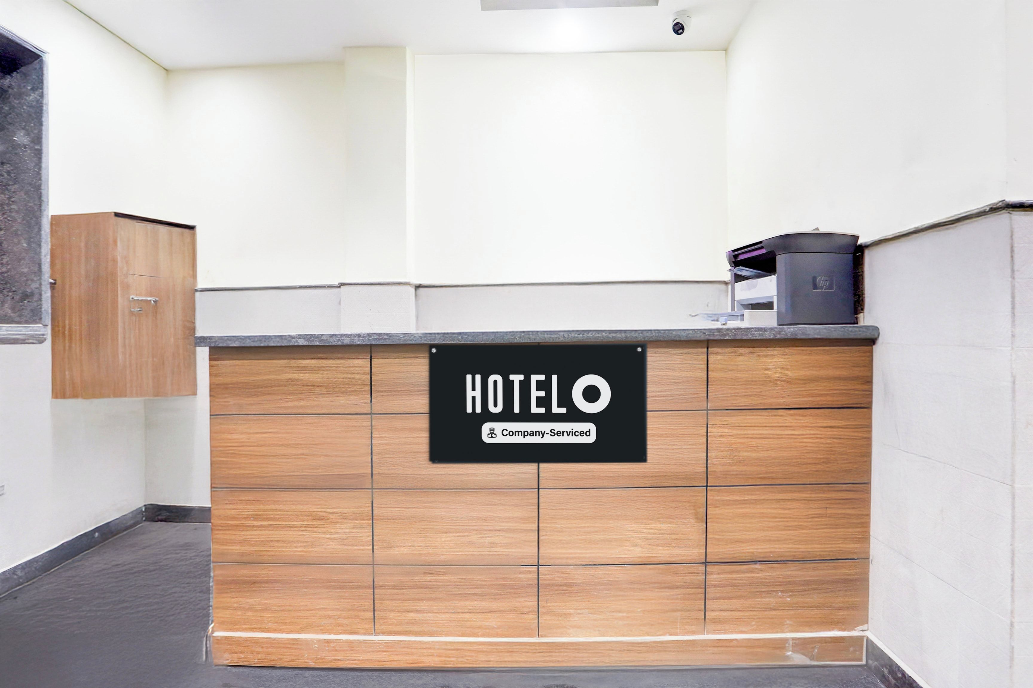 A hotel reception desk with a sign indicating it is company-serviced.