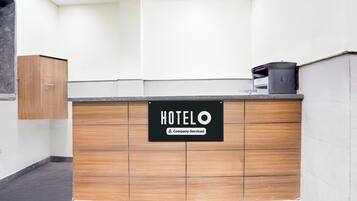 A hotel reception desk with a sign indicating it is company-serviced.