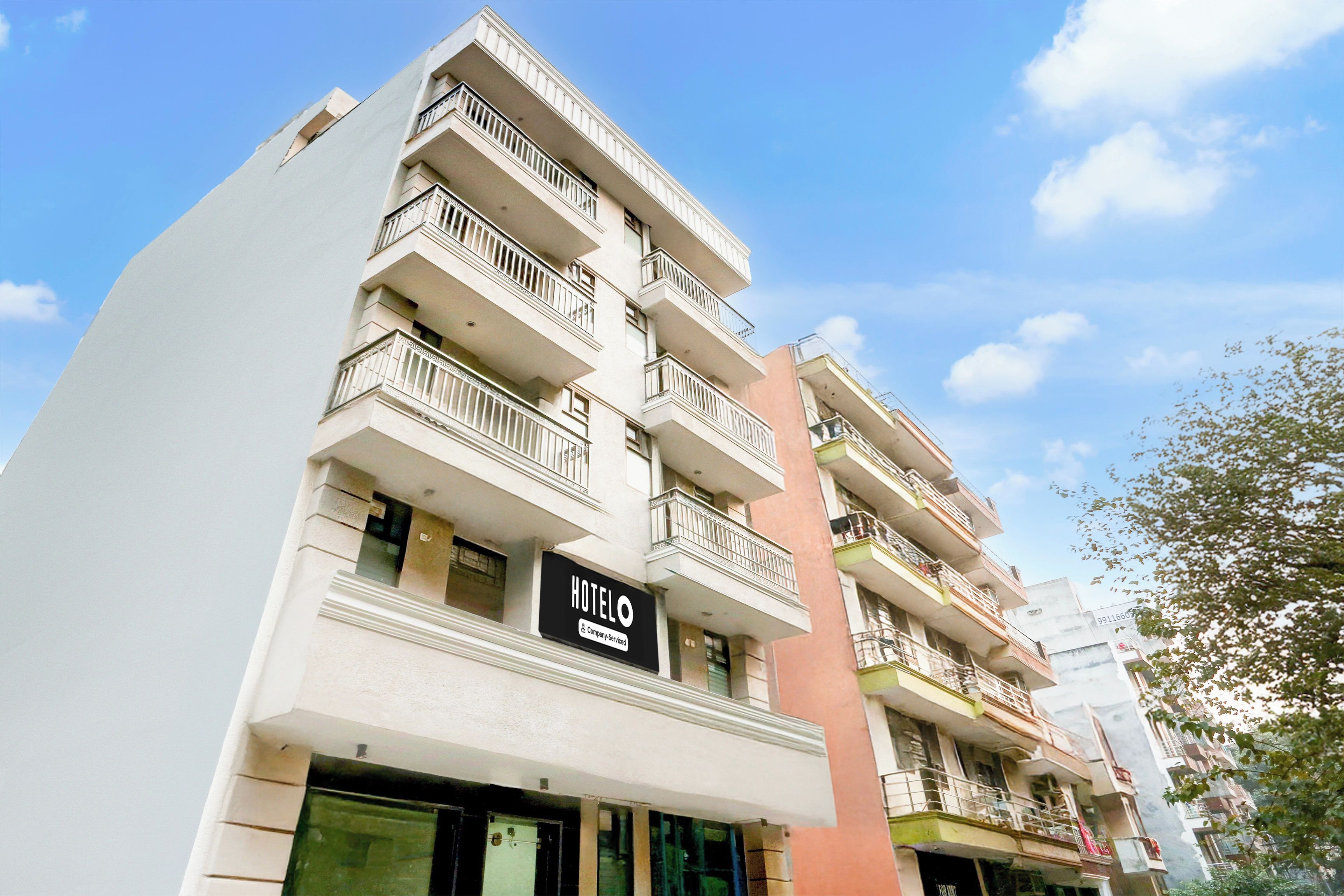 A multi-story hotel building with balconies and a sign indicating it is a company-serviced hotel.