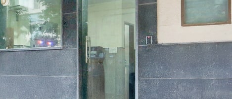 A building facade with a glass door and windows.