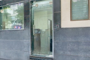 A building facade with a glass door and windows.