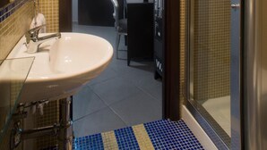 A bathroom with a sink, mirror, and shower area. - Il Taschino Suite (Naples)
