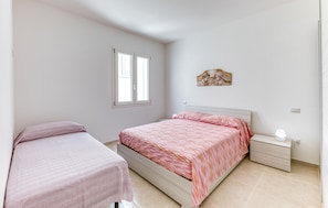 A bedroom with a bed, a nightstand, a window, and a wall-mounted artwork. - 1 bedroom stunning home in Torre San Giovanni (Torre San Giovanni)