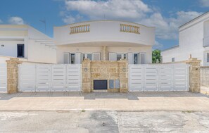 A modern two-story house with a stone facade, white shutters, and a gated entrance. - 1 bedroom stunning home in Torre San Giovanni (Torre San Giovanni)