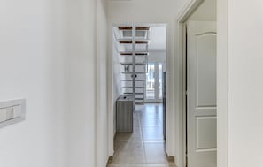 A narrow hallway with a built-in shelving unit and a door on the right. - 1 bedroom stunning home in Torre San Giovanni (Torre San Giovanni)