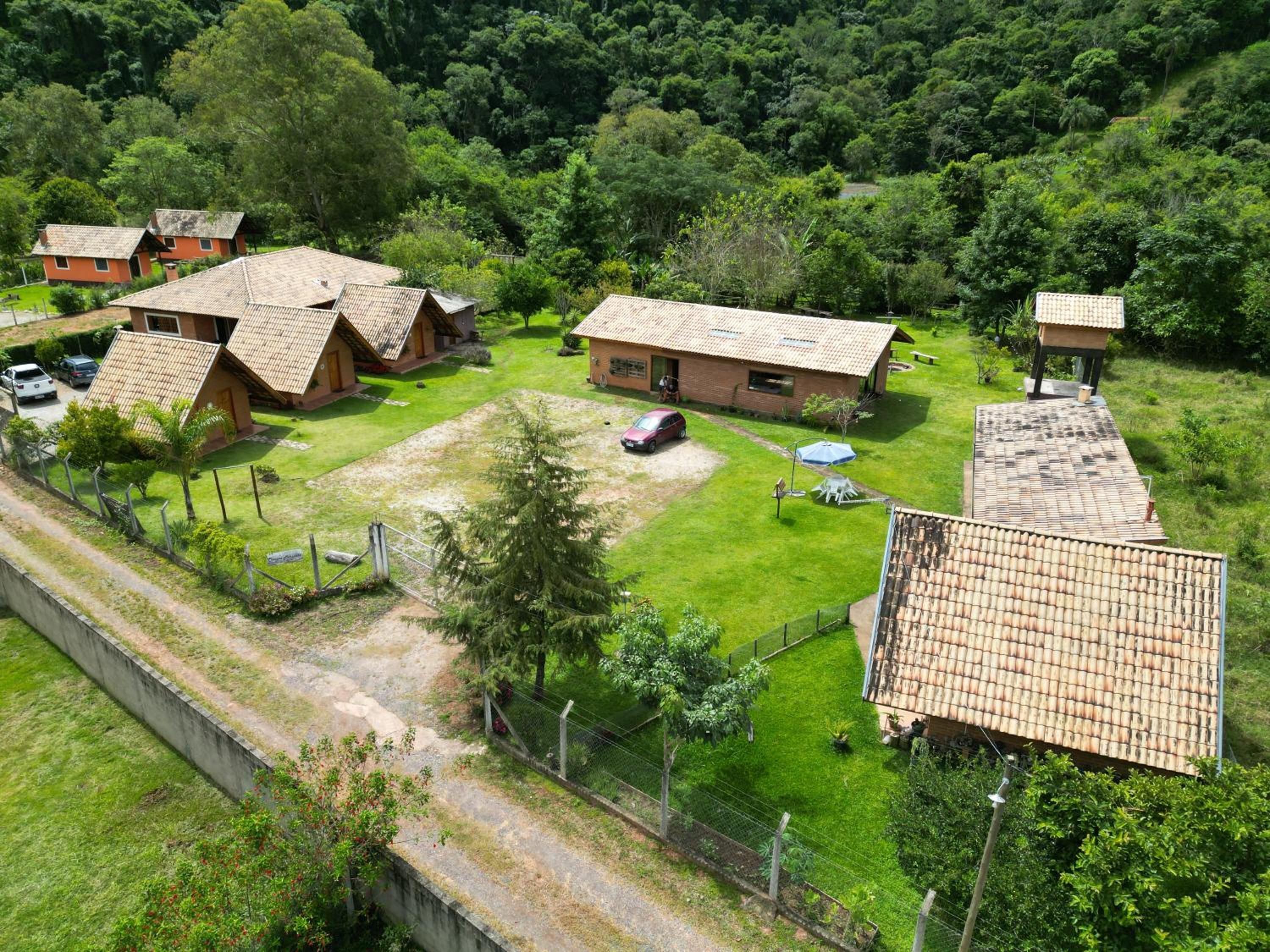 Um bairro residencial com várias casas, cal çada pavimentada e quintal cercado.