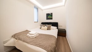 A bedroom with a bed, a nightstand, a window, and a wall-mounted artwork. - Tonight Homestay West Nanjing Road Shanghai Taigu Building (Shanghai)