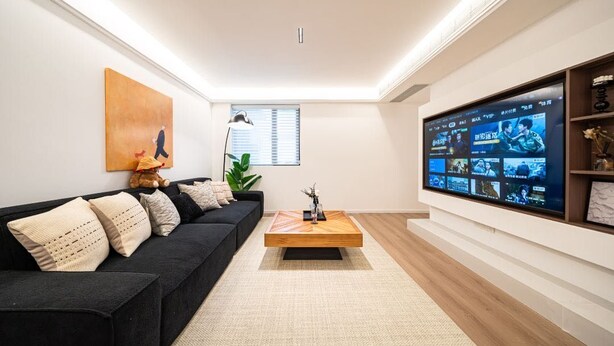 A modern living room with a black sofa, a wooden coffee table, and a large flat-screen TV mounted on the wall. - Tonight Homestay West Nanjing Road Shanghai Taigu Building (Shanghai)