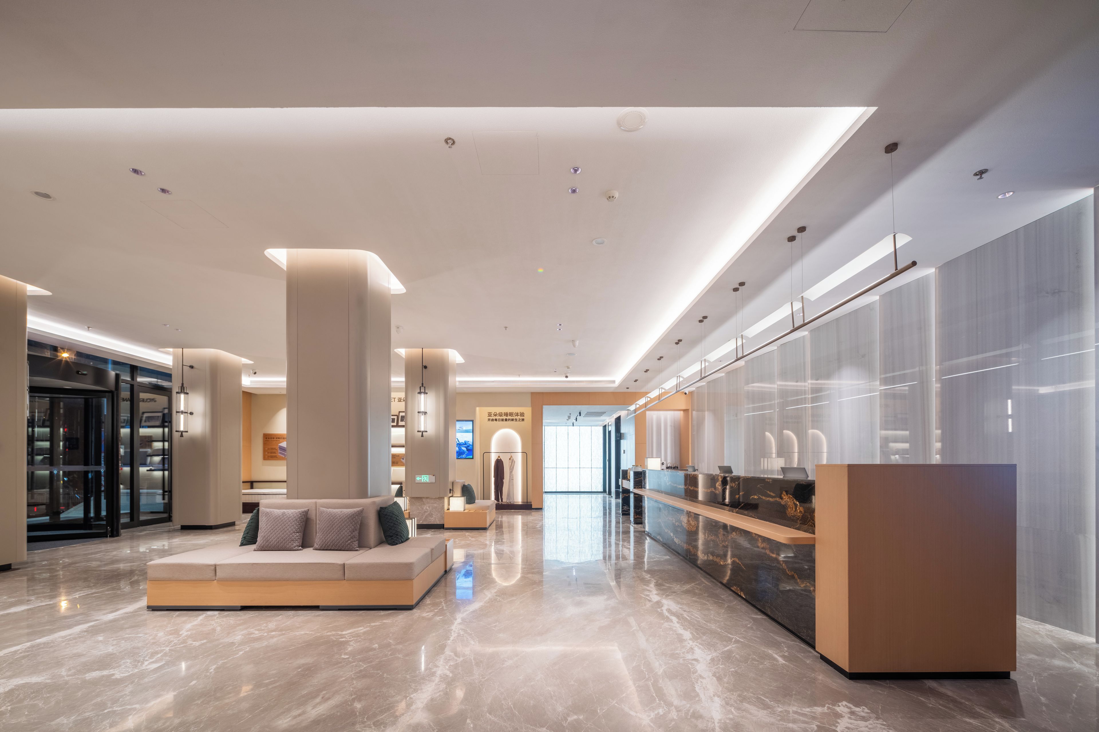 A spacious lobby with a reception desk, seating area, and a clear view of the entrance.