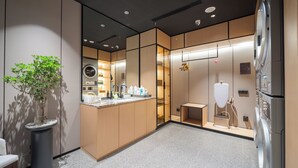 Un baño moderno con lavamanos, espejo y diversos artículos de aseo.