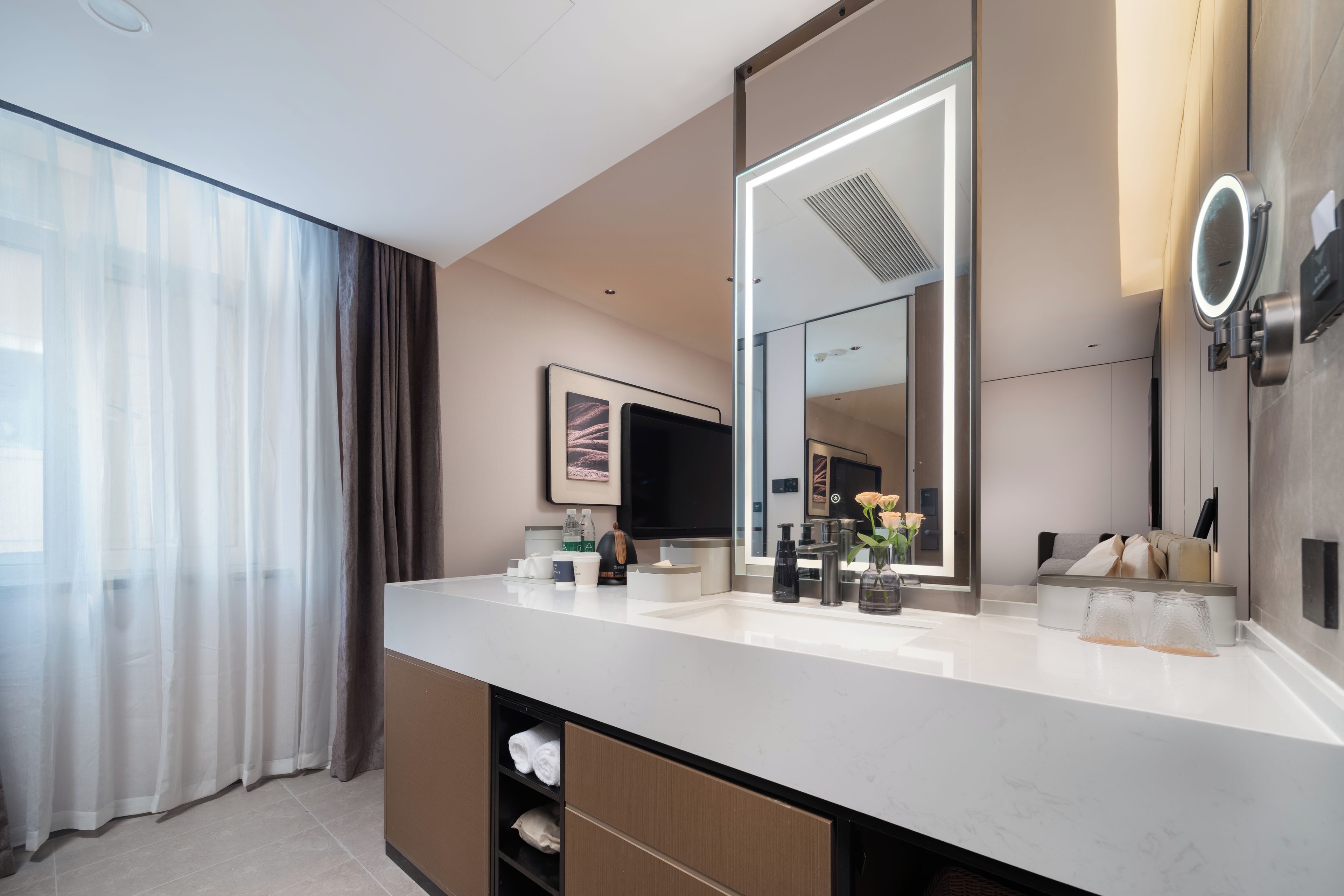 Un baño moderno con un espejo grande, un lavabo y una zona de ducha.
