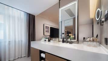 Un baño moderno con un espejo grande, un lavabo y una zona de ducha.