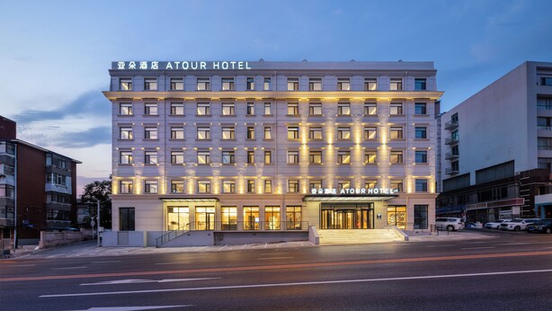 Un hotel de varios pisos con una entrada destacada y señalización iluminada.