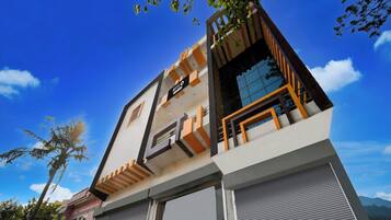 Een modern hotel met een opvallend bord, een balkon en uitzicht op de lucht.