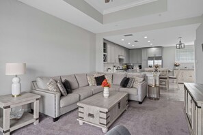 A modern living room with a grey sofa, a coffee table, and a side table with a lamp. - Reunion Resort Retreat with Game Room & Golf Views (Kissimmee)