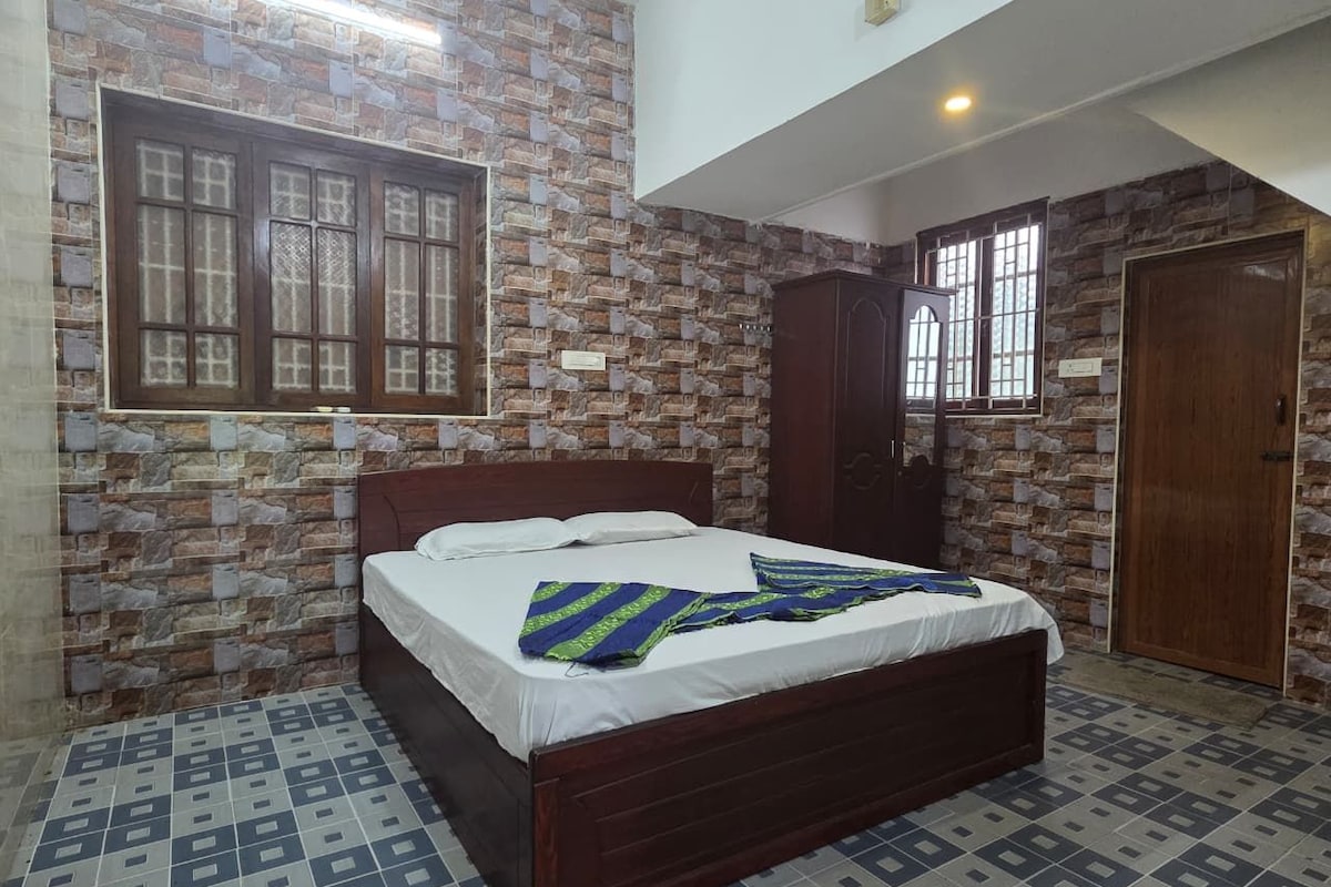A bedroom with a bed, a wardrobe, a window, and a door.