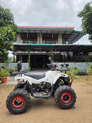 A white ATV parked in front of a building with a red roof and a covered entrance.