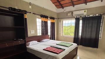 Un dormitorio con cama, armario, ventilador de techo y ventana con cortinas.