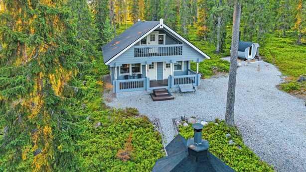A two-story cabin with a porch, surrounded by dense forest. - Tykkytie cottage by Interhome (Posio)