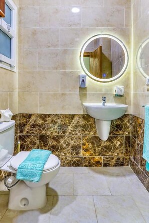 Ein Badezimmer mit Toilette, Waschbecken und Spiegel.