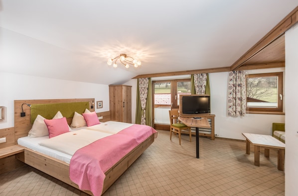 A bedroom with a bed, a TV, a desk, and a chair. - Vrbo Property (Ramsau am Dachstein)