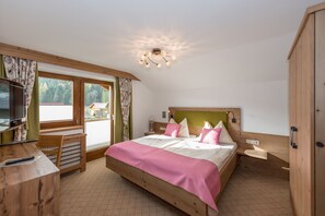 A bedroom with a bed, a desk, and a television. - Vrbo Property (Ramsau am Dachstein)