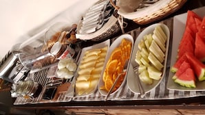 Ein reichhaltiges Buffet mit verschiedenen Speisen, darunter Brot, Käse, Obst und Beilagen.