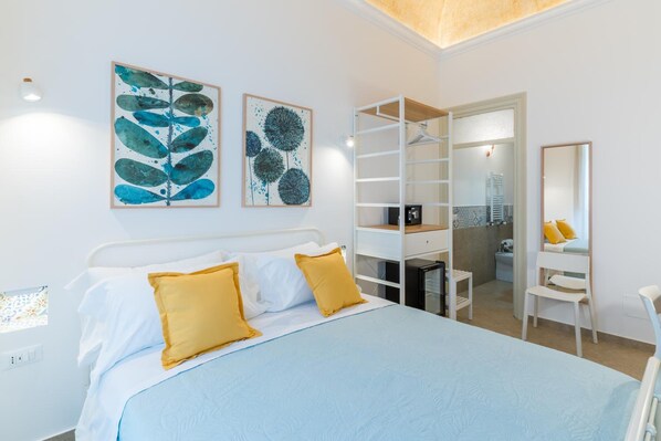 A bedroom with a bed, a wardrobe, a mirror, and artwork on the wall. - Mama Tita Rooms And Breakfast (Palermo)