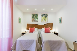 A hotel room with two beds, a large painting on the wall, and a nightstand with a lamp. - Mama Tita Rooms And Breakfast (Palermo)