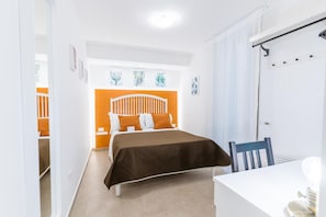 A bedroom with a bed, a chair, a desk, and a door. - Mama Tita Rooms And Breakfast (Palermo)