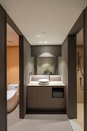 A modern bathroom with a round sink, a mirror, and a shower area. - Gray Hotel (Yongin-si)