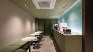 A narrow hallway with green seating, a kitchenette, and a 'STAFF ONLY' door. - Gray Hotel (Yongin)