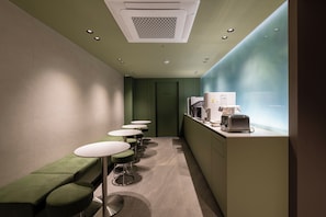 A narrow hallway with green seating, a kitchenette, and a 'STAFF ONLY' door. - Gray Hotel (Yongin-si)