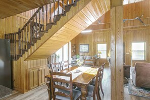 A wooden interior with a staircase, dining area, and living space.