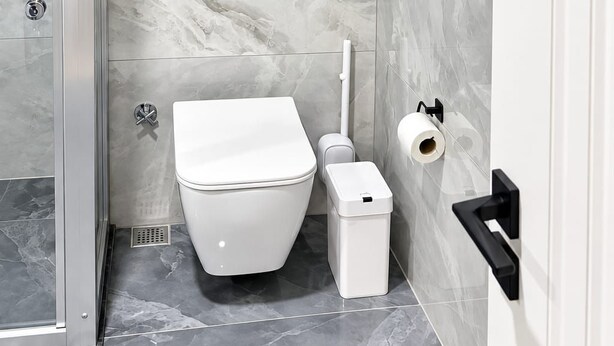 Un baño moderno con inodoro, bidé y cabina de ducha de vidrio.