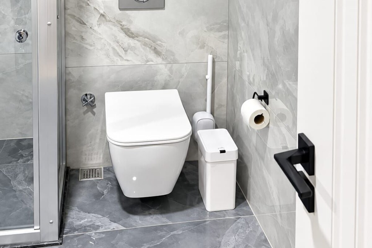 Un baño moderno con inodoro, bidé y cabina de ducha de vidrio.