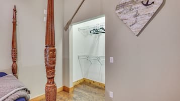 Une chambre avec un lit en bois, un portant à vêtements et un élément de décoration murale en forme de cœur.