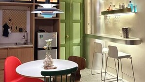 Een moderne keuken met een eethoek, met een ronde tafel, stoelen en een groene deur.