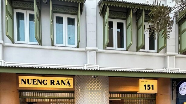 Een hotelentree met een bord waarop 'NUENG RANA' en het nummer '151' staan.