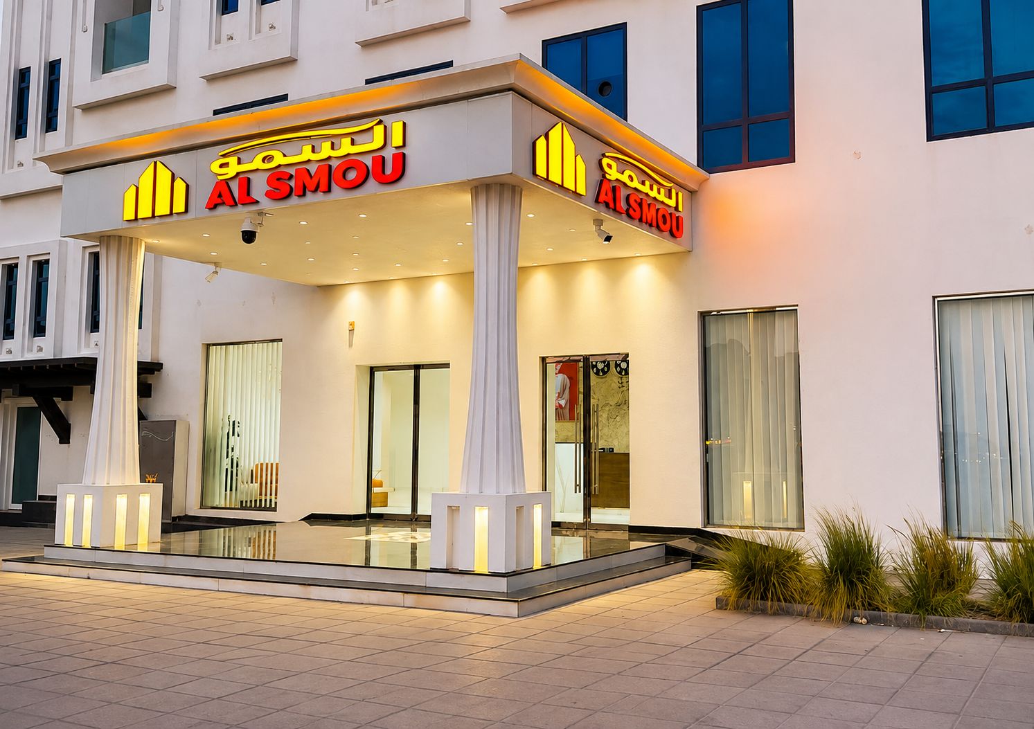 A hotel entrance with a modern design, featuring a covered entrance area and glass doors.